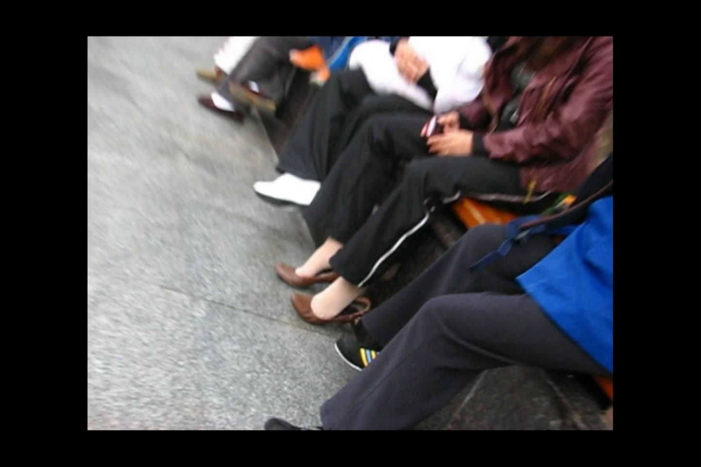 Lady with hot feet sits with friends and plays with shoes